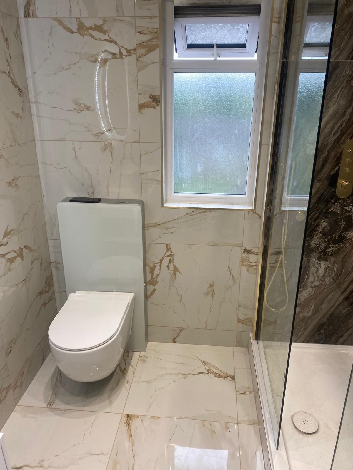 Finished bathroom with marble-effect tiles, wall-hung toilet and walk-in shower